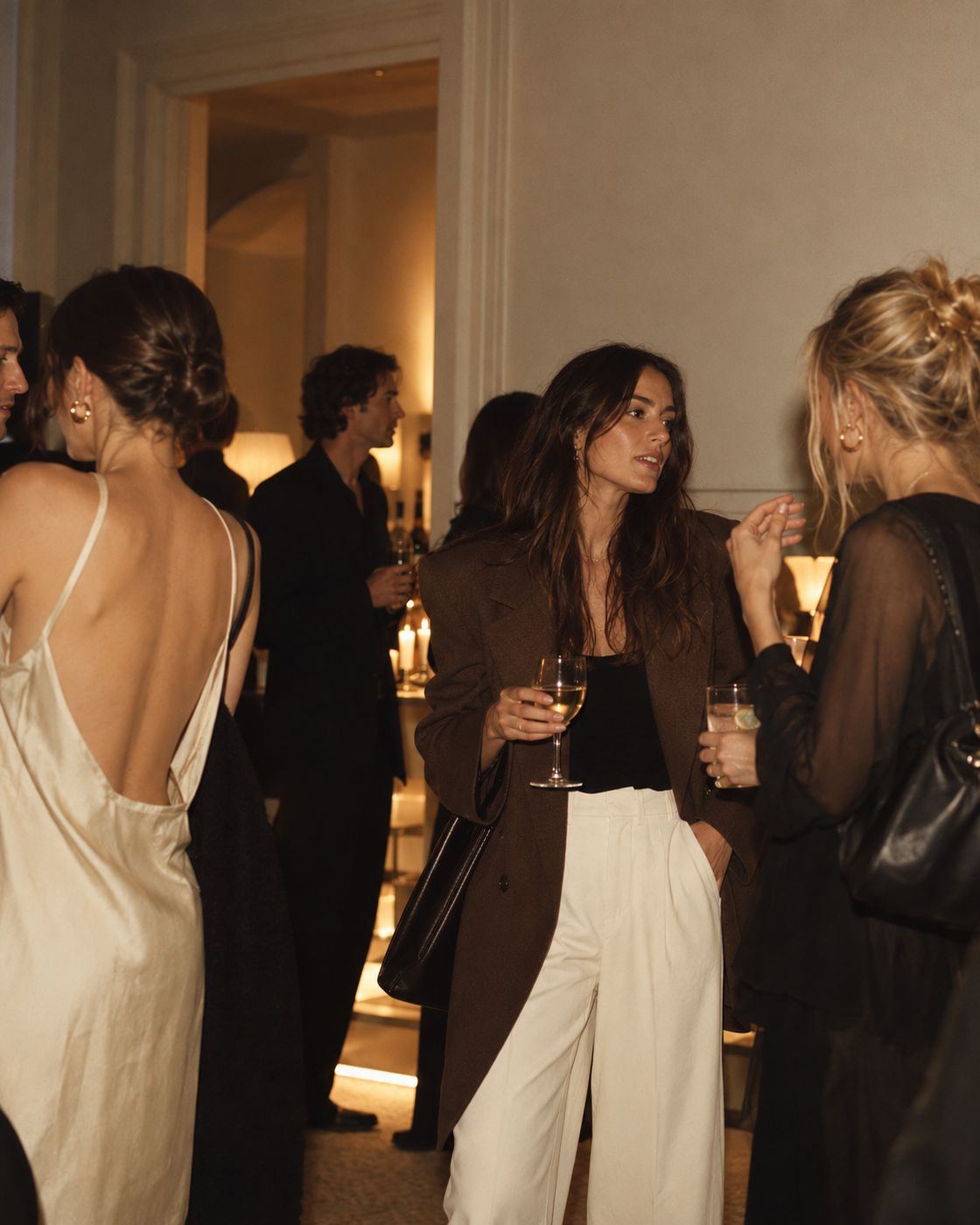Guests talking in a candlelit salon
